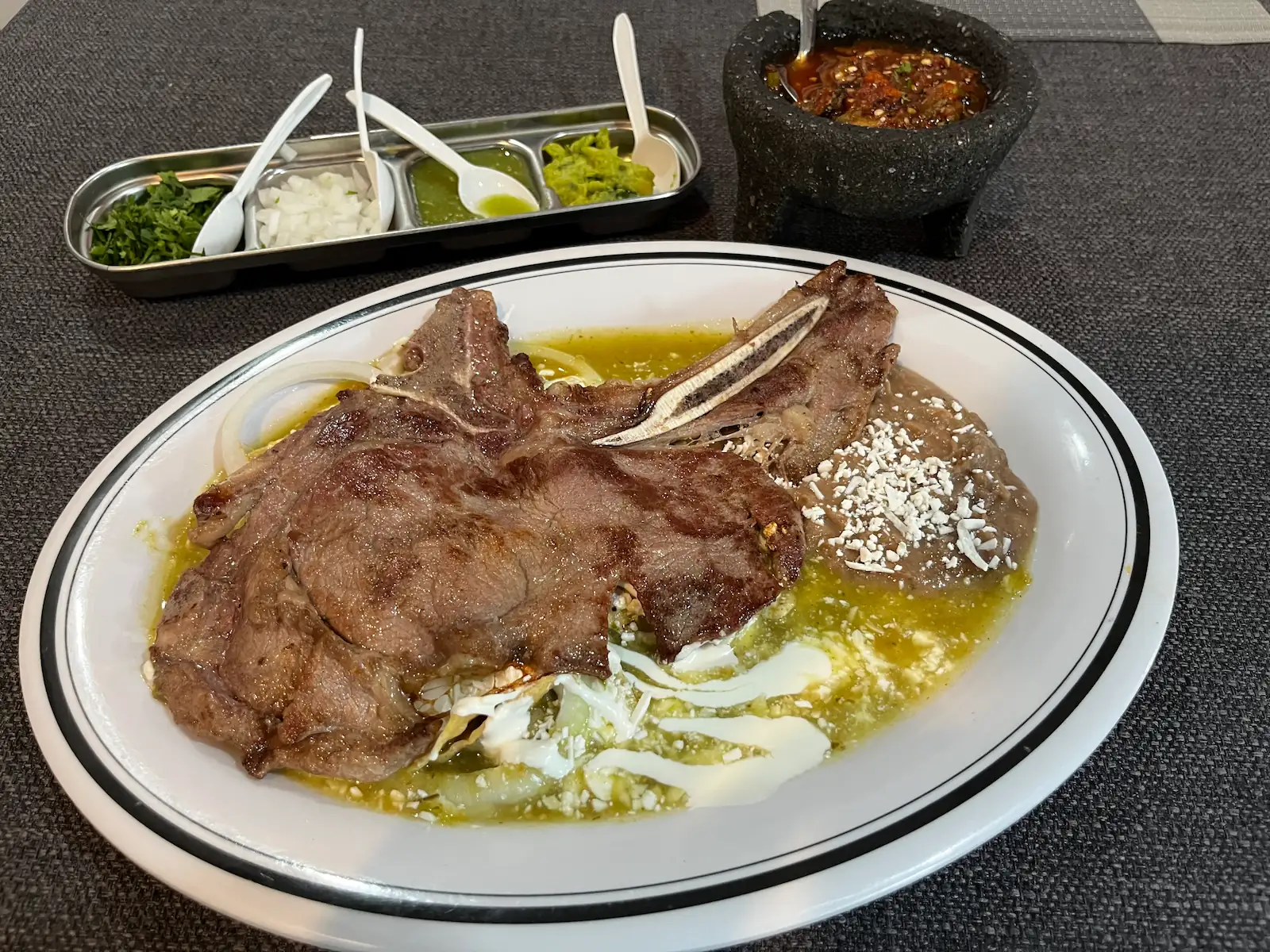 Costillas de cerdo a la parrilla servidas con guarnición en Restaurante Los Ángeles